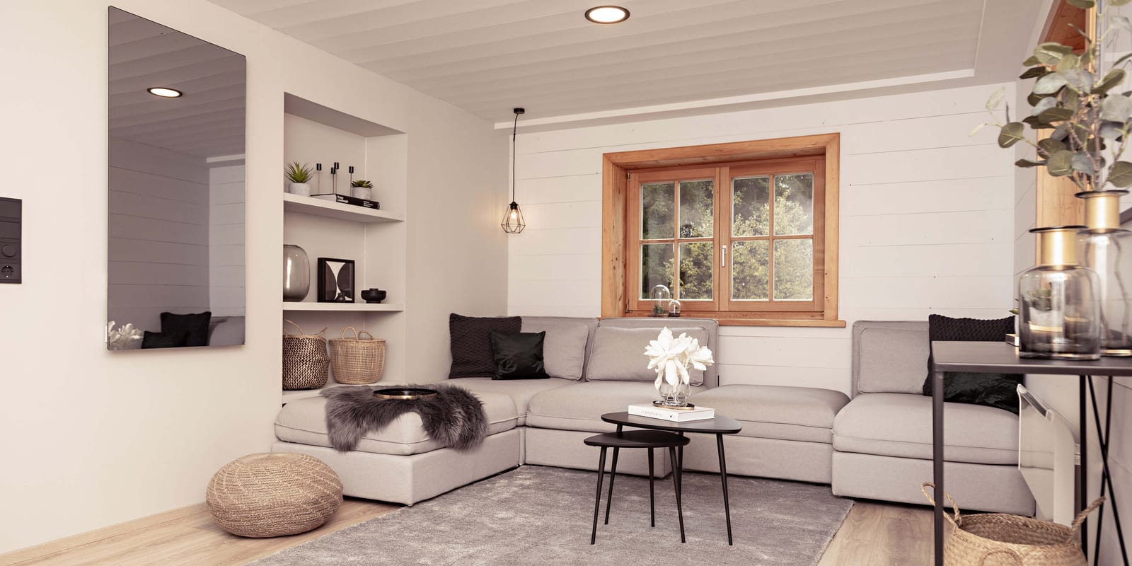 Heller Wohnbereich von Apartment Xaver mit großer Sofalandschaft, Holzfenster und Nischenregalen.